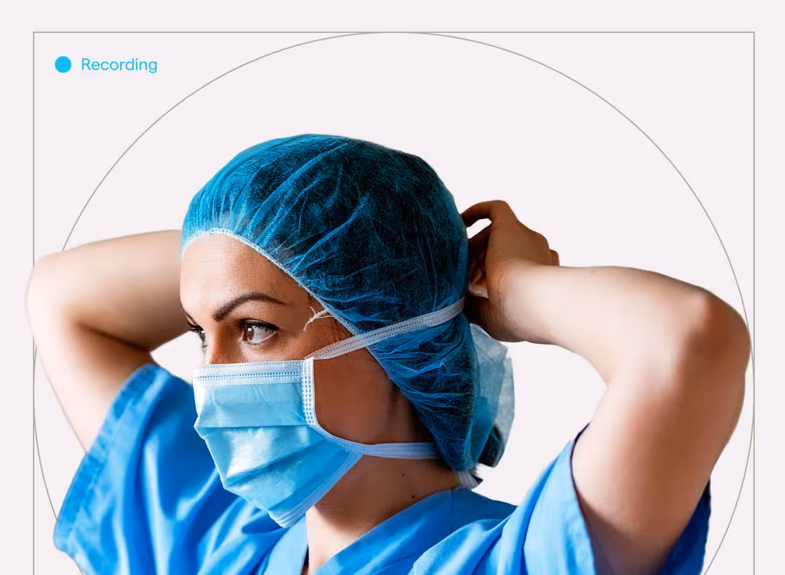 Nhân viên y tế mặc đồ mổ màu xanh đang điều chỉnh khẩu trang.